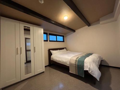 Un dormitorio pequeño con una cama y una ventana. en 舒心云舍, en Osaka