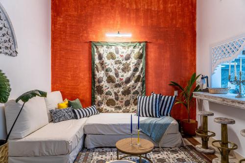 a living room with a couch and a red wall at Edificio ubicado en el centro de la ciudad dentro de la ciudad amurallada Edificio Ayos in Cartagena de Indias