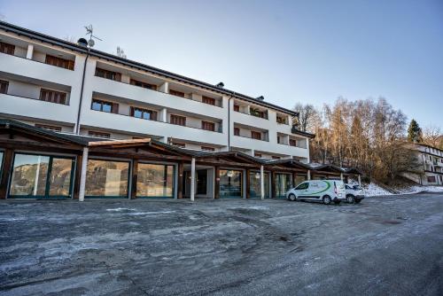 a white car parked in front of a building at Appartamento Polsa 4 in Brentonico