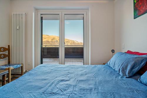 a bedroom with a bed with a blue comforter at Appartamento Polsa 4 in Brentonico