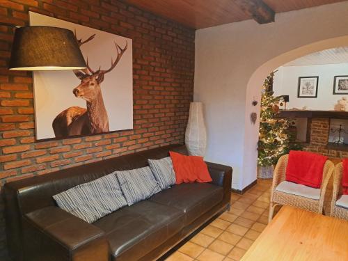 een woonkamer met een bank en een foto van een hert bij Les Grands Chais in Ortho