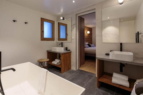 La salle de bains est pourvue d'une baignoire, de 2 lavabos et d'un lit. dans l'établissement Chalet Gloribel, à Chamonix-Mont-Blanc