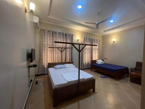 a bedroom with two beds and a tv in it at J & S LUGALLA HOUSE in Dar es Salaam