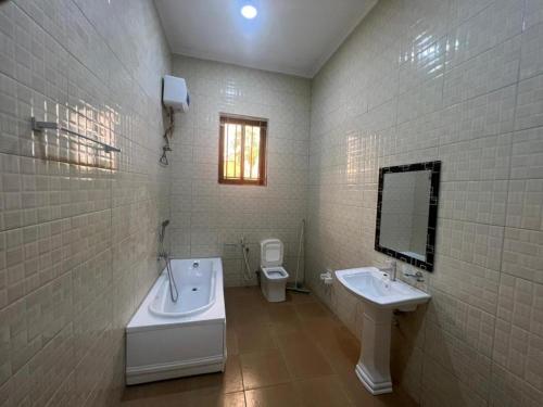 a bathroom with a tub and a sink and a toilet at J & S LUGALLA HOUSE in Dar es Salaam