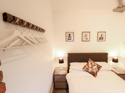a bedroom with a bed and a staircase with pictures on the wall at The Nest in Doncaster