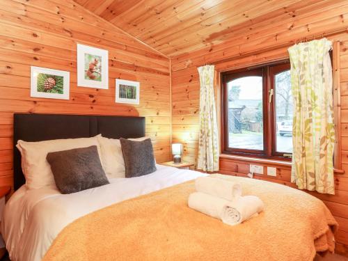a bedroom with a bed in a log cabin at Latrigg Lodge in Keswick