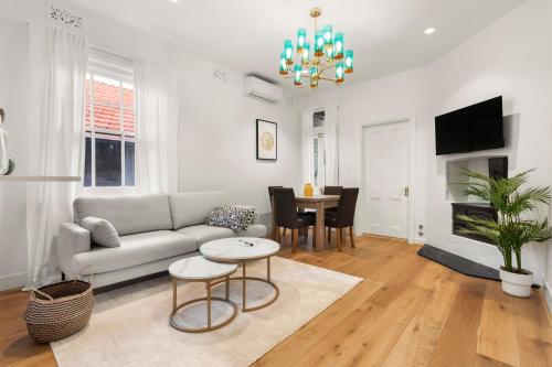a living room with a couch and a table at Stunning Terraced Apartment near the Sydney Opera House in Sydney