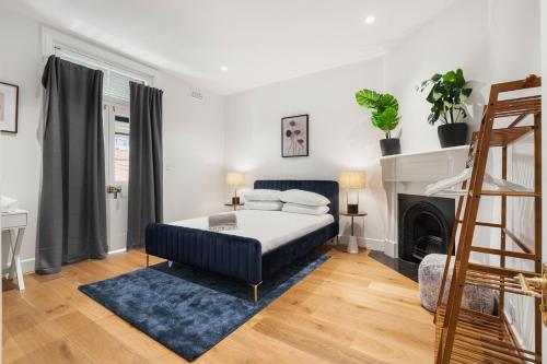 a bedroom with a blue bed and a fireplace at Stunning Terraced Apartment near the Sydney Opera House in Sydney