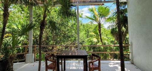 a table and chairs on a balcony with palm trees at Casa Ambar Tulum - Great Location in Tulum