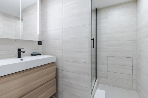 uma casa de banho com um lavatório e um chuveiro em HSH Parmentier-Couronnes I Appartement Design 6P-2BR em Paris