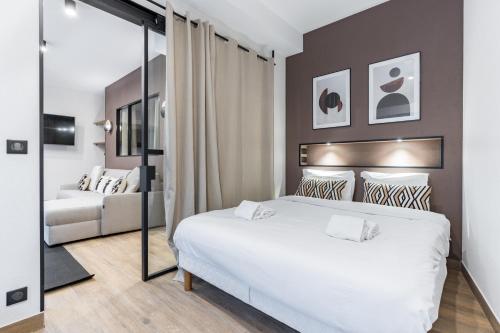 a bedroom with a large white bed and a couch at HSH Parmentier-Couronnes I Appartement Design 6P-2BR in Paris