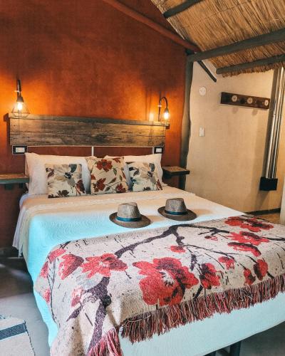 a bedroom with a bed with two hats on it at La Saucina - Cabaña Rústica Chic in Tunuyán