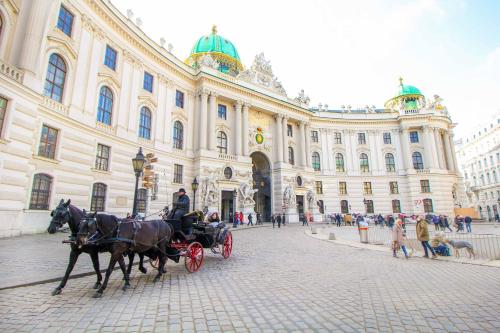 a horse drawn carriage in front of a large building at SI apartments - Smart Inn in Vienna