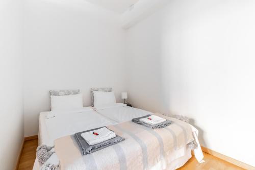 two beds in a room with white walls at Cozy, spacious and calm apartment central Helsinki in Helsinki