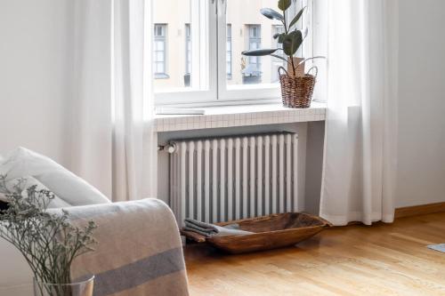 a living room with a chair and a radiator and a window at Cozy, spacious and calm apartment central Helsinki in Helsinki