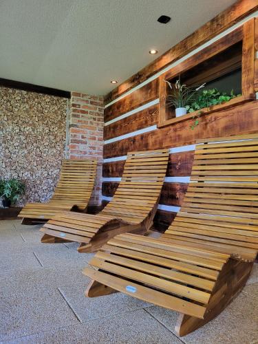 3 chaises en bois sont bordées d'un mur dans l'établissement Hotel Styl Hlinsko, à Hlinsko