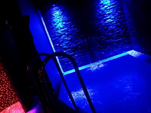 una piscina con luces azules y moradas en Hotel Styl Hlinsko, en Hlinsko