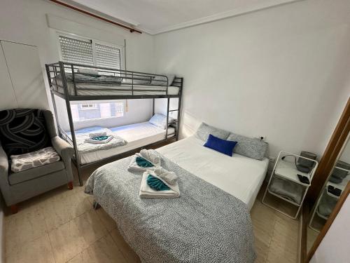 ein Schlafzimmer mit zwei Etagenbetten und einem Spiegel in der Unterkunft Homely Apartments Vitoria in Torrevieja