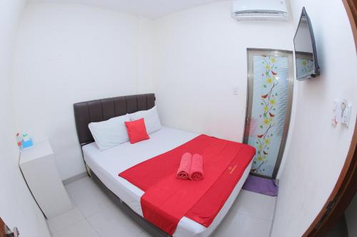 a small bedroom with a bed with pink slippers on it at grand koetaradja permai hotel in Luengbata