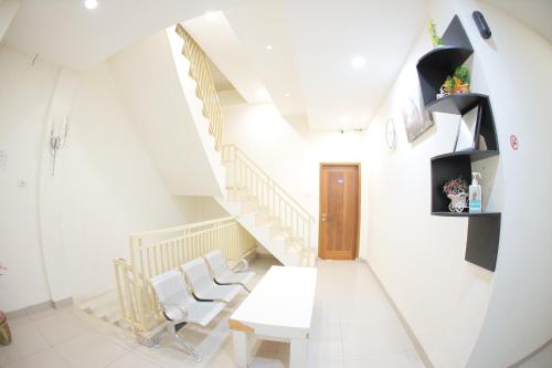 a room with a table and chairs and stairs at grand koetaradja permai hotel in Luengbata