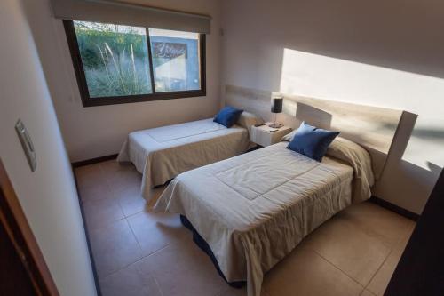 a hotel room with two beds and a window at Estancia Yolanda C4 - by Inside in Ciudad Lujan de Cuyo