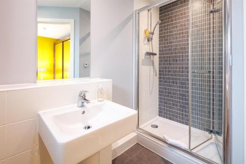 een badkamer met een wastafel en een douche bij The Boat House Apartment by Cliftonvalley Apartments in Bristol