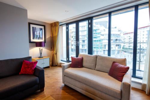 a living room with a couch and a large window at The Boat House Apartment by Cliftonvalley Apartments in Bristol
