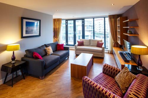 een woonkamer met een bank en een stoel bij The Boat House Apartment by Cliftonvalley Apartments in Bristol