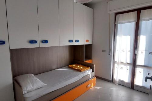 een kleine kamer met een bed en een raam bij Rosa's House in Sarnano