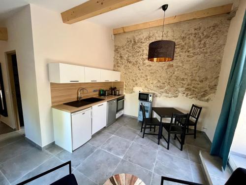 kuchnia i jadalnia ze stołem i krzesłami w obiekcie La Parenthèse du Var - Gîte avec grande terrasse vue sur piscine w mieście Saint Antonin du Var