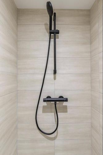 une douche murale avec un pommeau de douche. dans l'établissement HSH Parmentier-Couronnes II Appartement Design 4P-1BR, à Paris