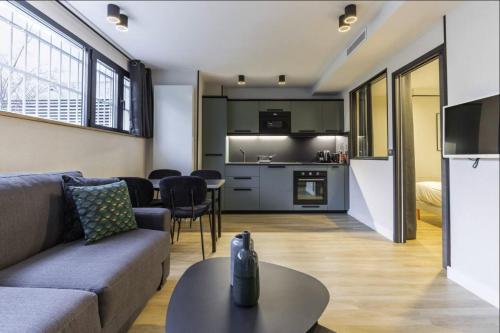 un salon avec un canapé et une table dans l'établissement HSH Parmentier-Couronnes II Appartement Design 4P-1BR, à Paris