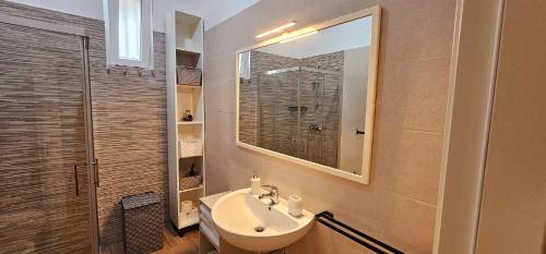 a bathroom with a sink and a mirror at Seaside Villa with Hot Tub, 5mins walk from the sea in Torre rinalda