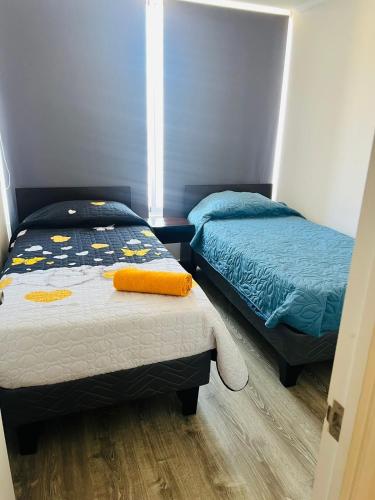 1 dormitorio con 2 camas y ventana en Departamento Vista al Mar, en Iquique
