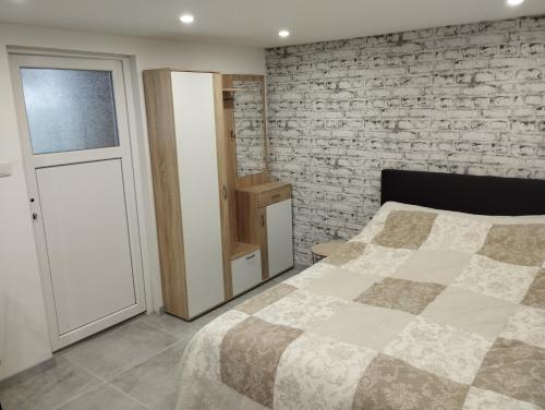 1 dormitorio con cama y pared de ladrillo en Studio, en Haguenau