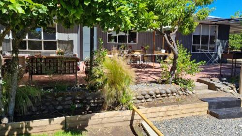 a garden with a table and chairs in front of a house at Agradable casa con Tina de agua Caliente y Piscina in Quillón