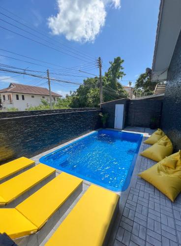 a swimming pool with yellow cushions next to at L.C. Apartments in Nathon Bay