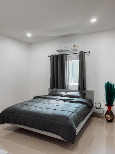een bed in een witte kamer met een raam bij L.C. Apartments in Nathon Bay