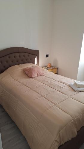 Una cama con una almohada rosa encima. en Marcella va a Civita en Bagnoregio