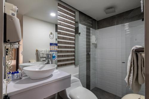 a bathroom with two sinks and a shower at Hotel Torre Poblado in Medellín