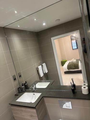 uma casa de banho com 2 lavatórios e um espelho grande em Richardson Deluxe Apartments (2-Bed) em Londres