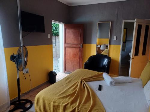 a bedroom with a bed and a room with a fan at Horizon Bed and Breakfast in Roodepoort