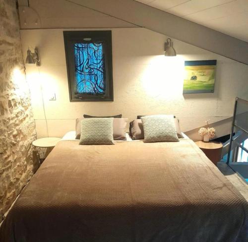 a bedroom with a large bed with a painting on the wall at Holiday Loft 58 in Arbois