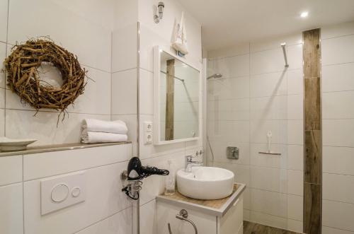 Baño blanco con lavabo y espejo en Windrose, en Wilhelmshaven