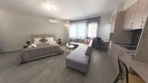 a bedroom with a bed and a couch and a table at Sidus Condos in Veria