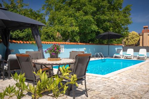 a patio with a table and chairs next to a pool at Rustic villa Casa Tessa with outdoor pool in Tar in Tar