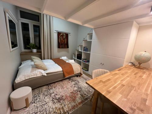 1 dormitorio con cama y mesa de madera en Elegancki Apartament Polonia Residence z widokiem na centrum Łodzi i prywatnym parkingiem, en Łódź