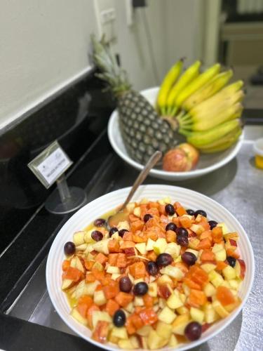 two plates of food on a counter with fruit at Hotel Beaga Convention Expominas by MHB in Belo Horizonte