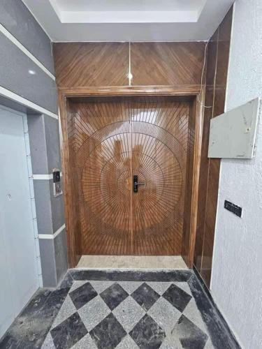 een houten deur in een kamer met een geruite vloer bij Long An Guest Rooms in Tân An