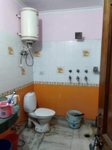 a bathroom with a toilet and a water tank at Long An Guest Rooms in Tân An